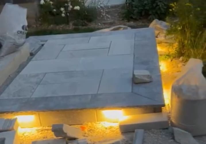 Elegant front patio design with flower beds and decorative lighting