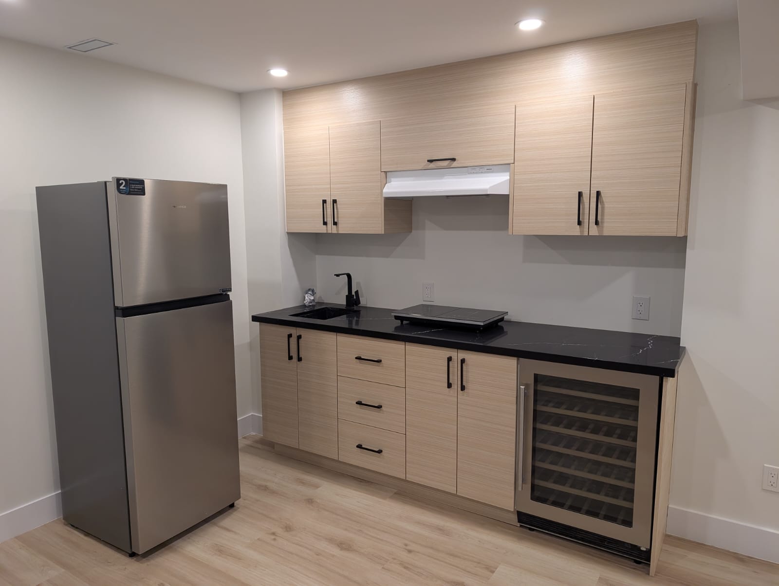 Finished basement featuring a sleek, functional kitchenette with modern fixtures.